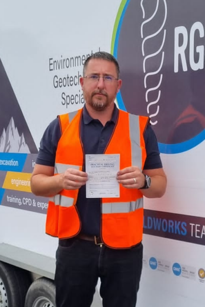 Man holding pass cerificate for HGV Driver Training Category C+E with PFS Training